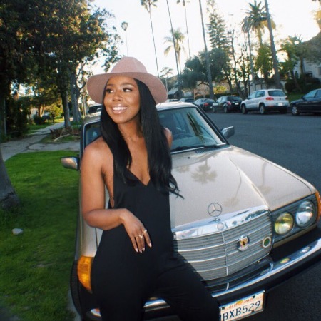 Nia Jervier posing with the vintage car. 